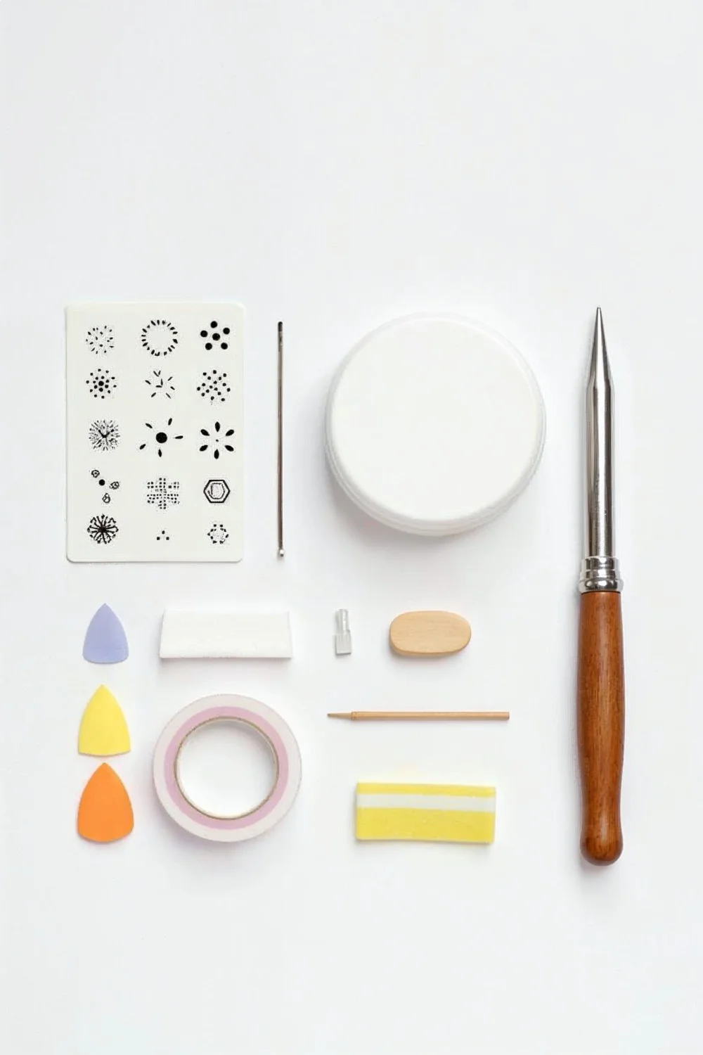 Flat lay of essential nail art tools including dotting tools, stamping plates, makeup sponges, and striping tape arranged on white background