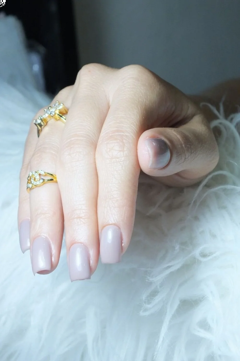 neutral nails with one accent nail in school colors against textbooks and school supplies