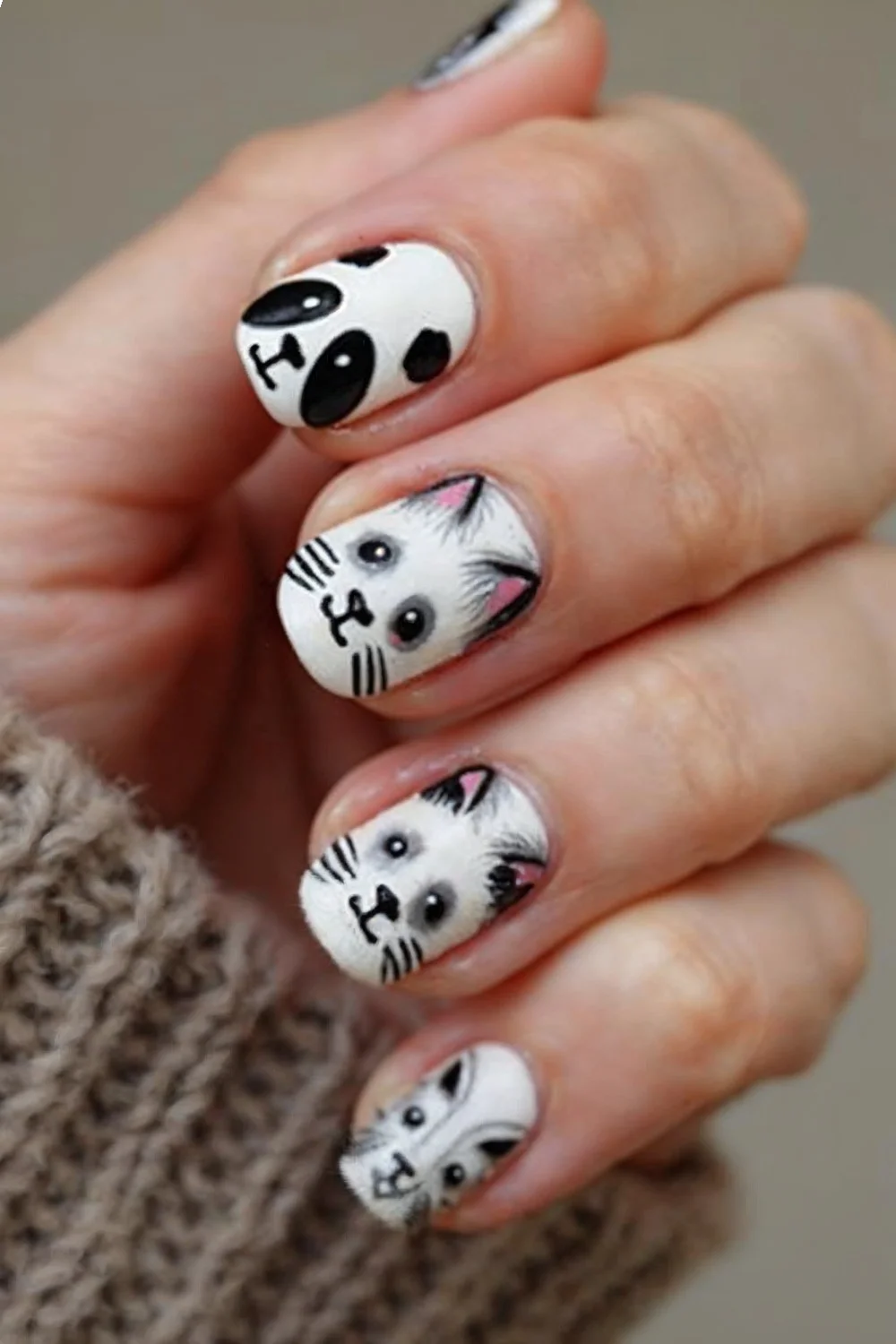 Detailed shot of animal face nail art showing panda and cat designs with clear visibility of facial features and proportions