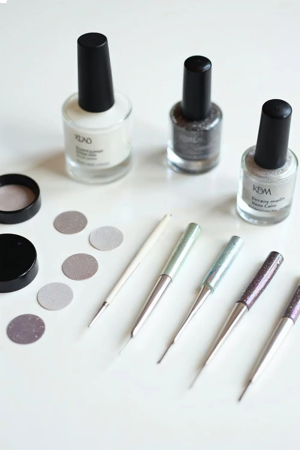 Flat lay of chrome nail supplies including silver and holographic chrome powders, gel base coat, no-wipe top coat, and applic