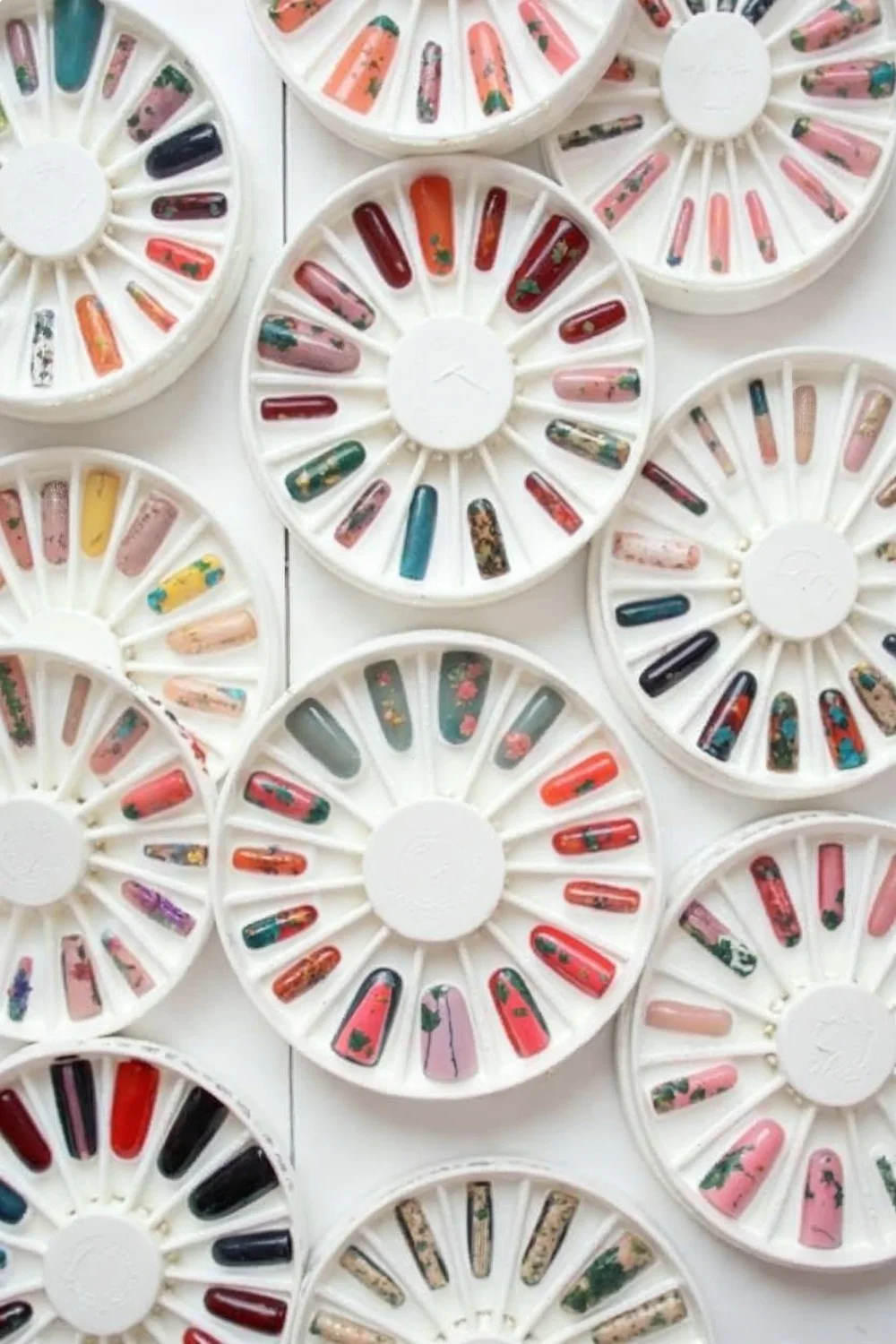 Flat lay of 10 different spring nail designs on nail wheels, showing the variety of techniques and color combinations