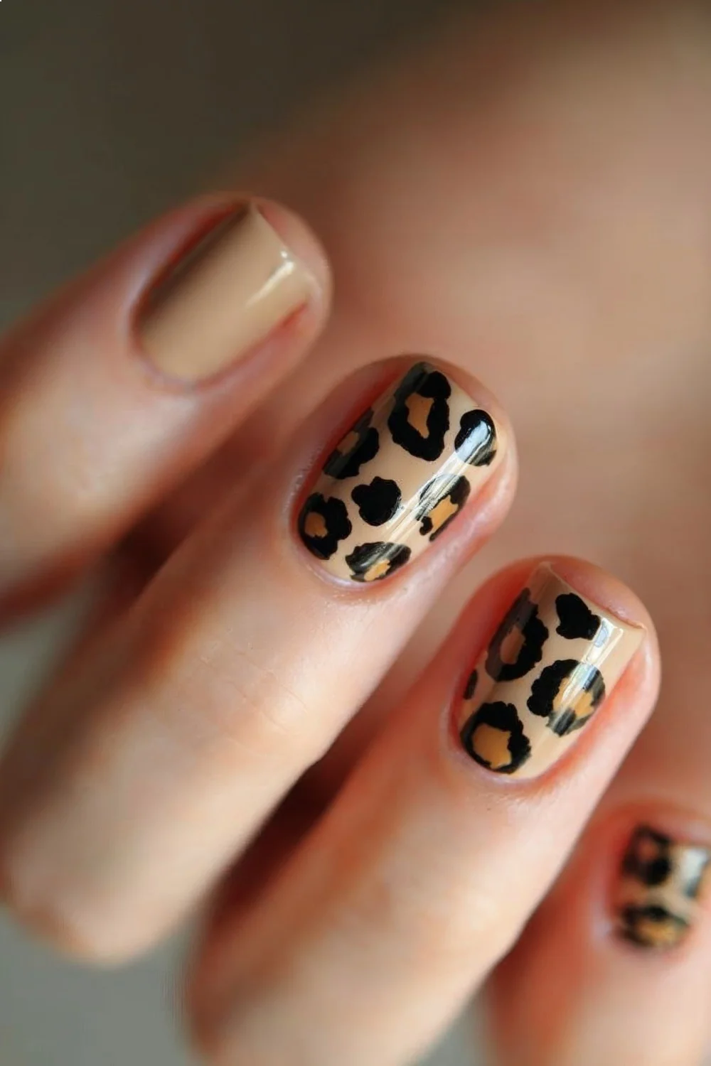 Matte beige nails featuring glossy brown leopard spots in an organic pattern, showcasing matte nail designs