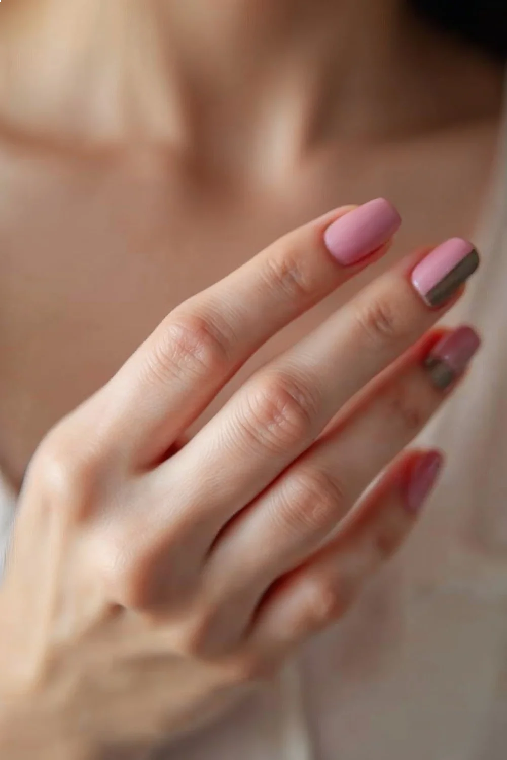 Nude pink nails with a matte finish on the bed and glossy coral pink tips