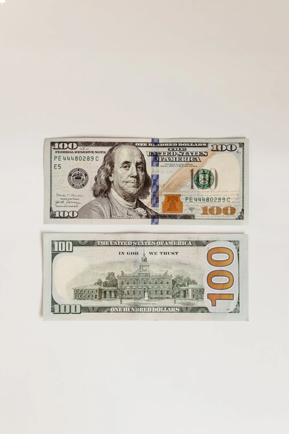 Two hundred dollar bills laid side by side on a white background