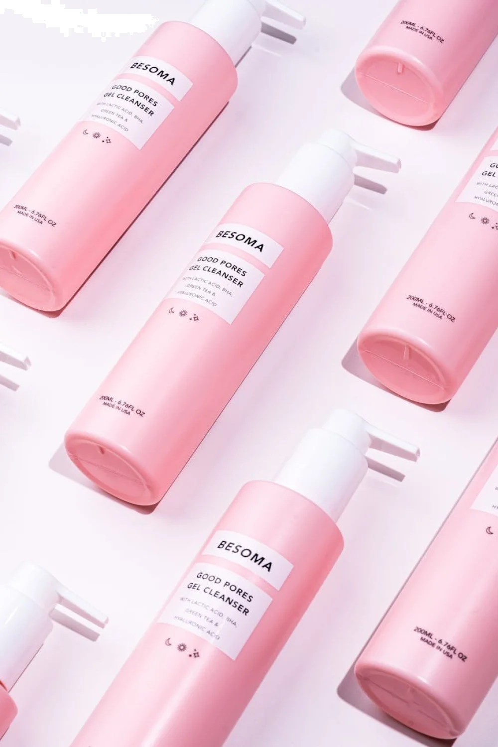 Flat lay of pastel gel bottles arranged with spring flowers, showing actual color swatches on nail tips