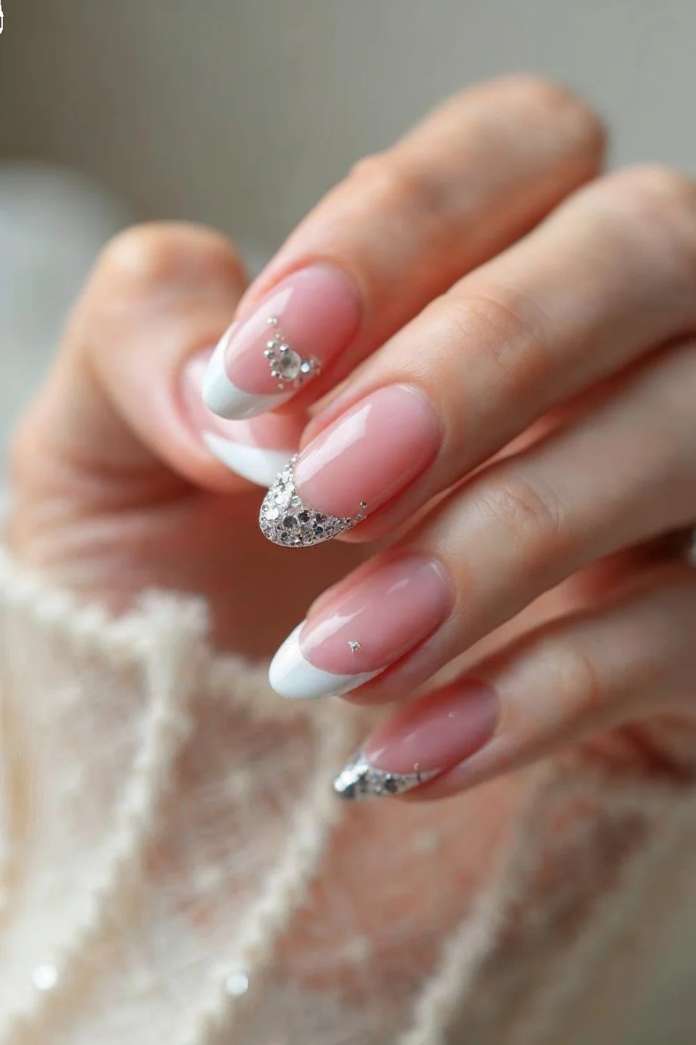 coral pink french tips with silver glitter accents on long almond-shaped nails